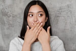 asian woman hidding smile with hands